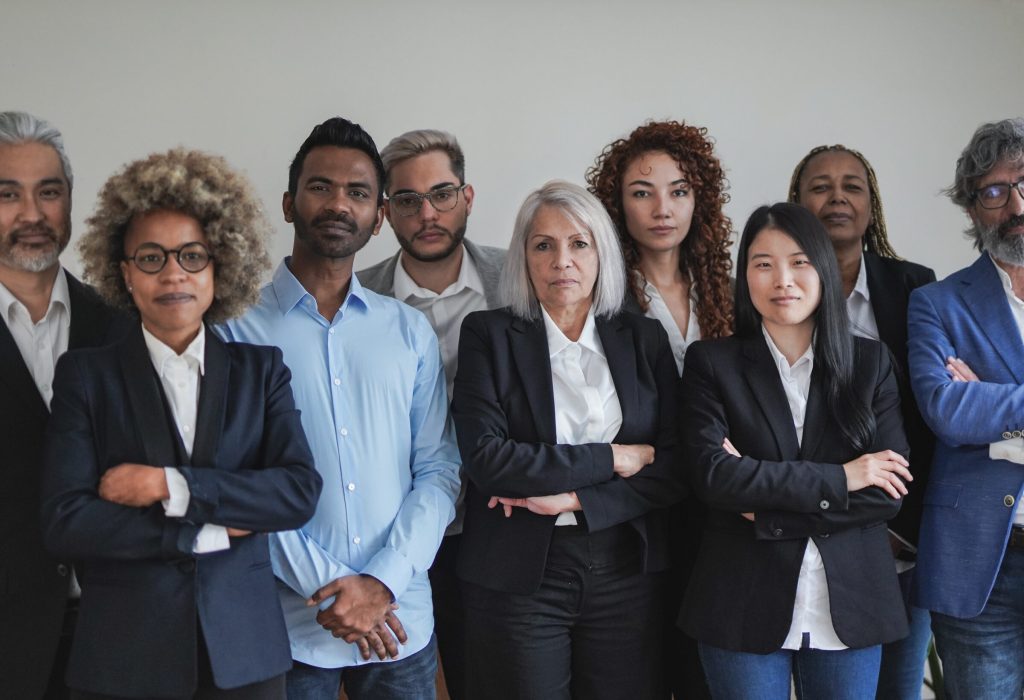 Group of multi generational business people looking serious on camera inside coworking office